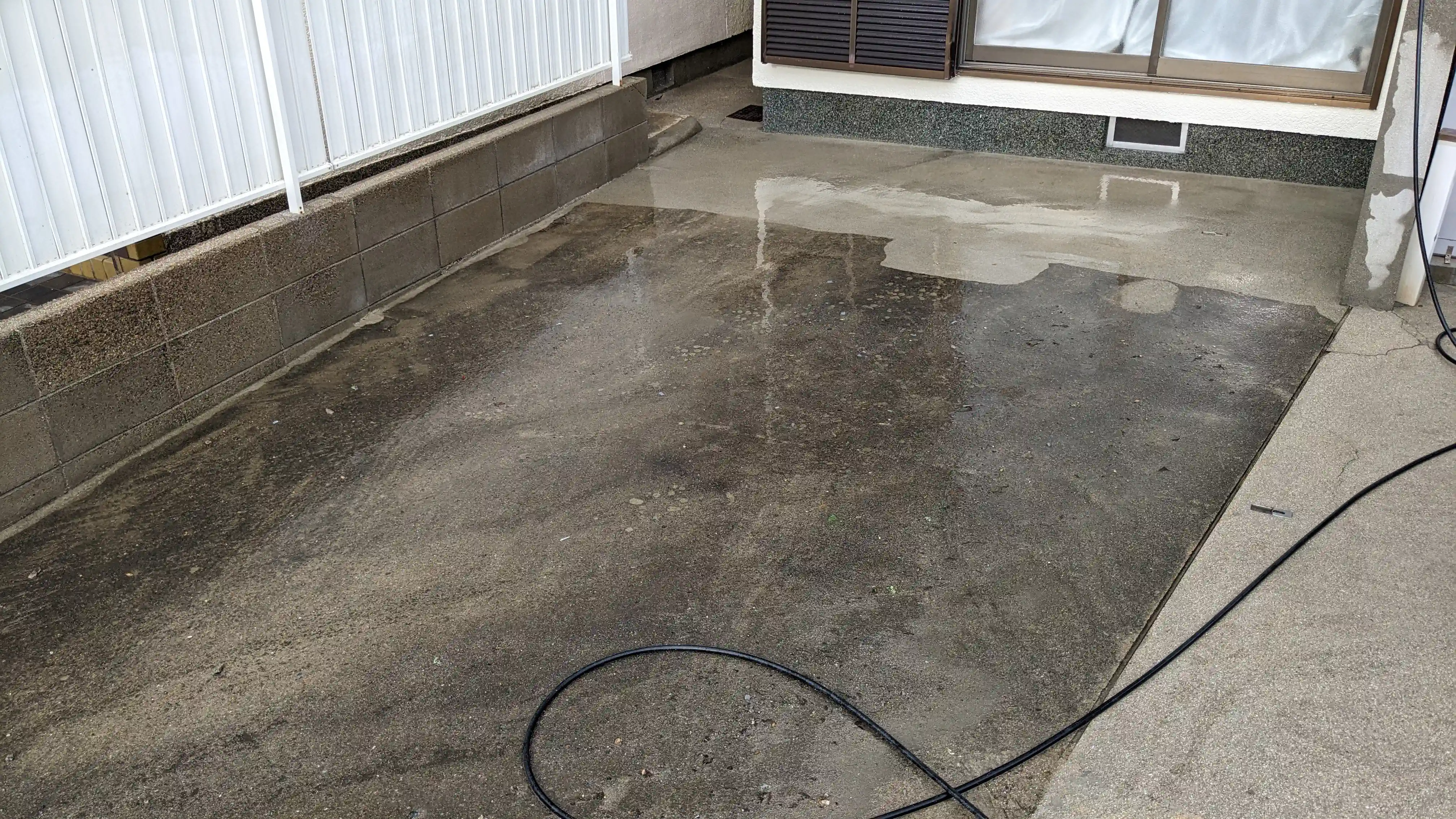 Wide view of concrete driveway and wall cleaning results at a Japanese house